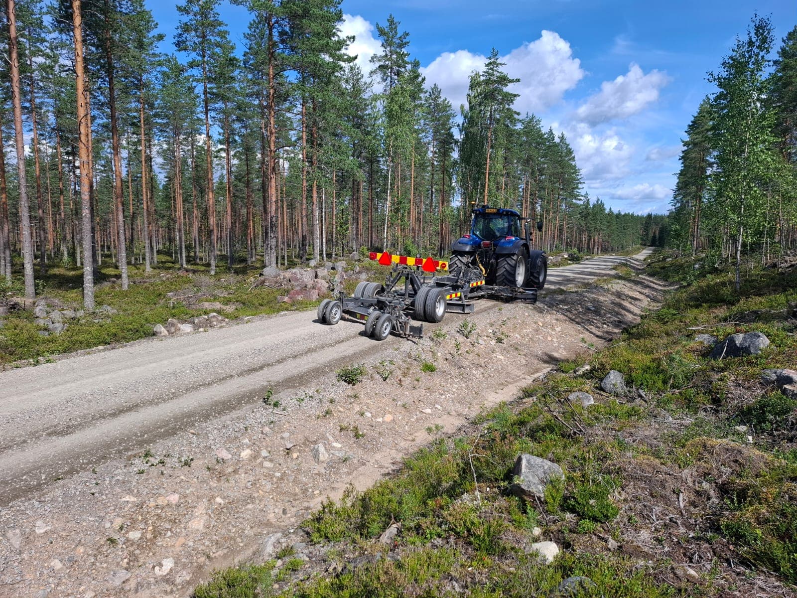 Traktori ja tielana kesäisellä soratiellä